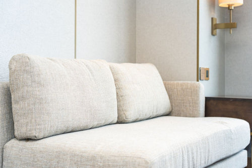 Upholstered sofa with light fabric cushions in a modern interior